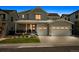 This charming two-story home features a covered porch, two-car garage, and well-manicured lawn on a tree-lined street at 11053 Bright Sky Cir, Littleton, CO 80125