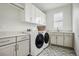 Convenient laundry room with modern washer, dryer, cabinets, and stylish tile flooring at 11053 Bright Sky Cir, Littleton, CO 80125