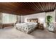 Bedroom with floral bedspread and curtains, carpet floors, wood ceiling, and chest at 1016 Stearns Ave, Boulder, CO 80303