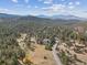 A high angle shows a private lot with a house nestled among mature evergreen trees at 30444 Ruby Ranch Rd, Evergreen, CO 80439
