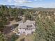 The house is on a large lot surrounded by pine trees and has a deck and a hot tub at 30444 Ruby Ranch Rd, Evergreen, CO 80439
