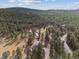 A beautiful aerial view of a home surrounded by a dense forest and nature at 30444 Ruby Ranch Rd, Evergreen, CO 80439
