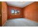 An empty bedroom is painted terracotta with a view of the outdoors at 30444 Ruby Ranch Rd, Evergreen, CO 80439