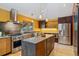 Modern kitchen with stainless steel appliances, an island with a wood finish, and natural wood cabinets at 30444 Ruby Ranch Rd, Evergreen, CO 80439