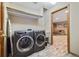 Functional laundry room with modern washer and dryer units and convenient shelving at 30444 Ruby Ranch Rd, Evergreen, CO 80439