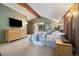 Bright bedroom with exposed beam vaulted ceiling, deck access, and wood accent wall at 30444 Ruby Ranch Rd, Evergreen, CO 80439