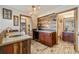 Stylish wet bar with rustic wood accents, mini-fridge, and access to a bathroom at 30444 Ruby Ranch Rd, Evergreen, CO 80439