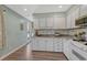 Bright kitchen features white cabinets, stainless steel appliances, granite counters and wood-look flooring at 8325 Elati St, Denver, CO 80221