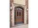 Beautiful exterior front door featuring an arched entryway, decorative stone accents, and vintage lighting at 3132 E 17Th Ave # B, Denver, CO 80206