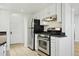Galley kitchen featuring white cabinetry, stone counters, and stainless steel appliances at 3132 E 17Th Ave # B, Denver, CO 80206