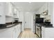 Galley kitchen featuring white cabinetry, stone counters, and stainless steel appliances at 3132 E 17Th Ave # B, Denver, CO 80206