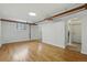 Spacious living space featuring hardwood floors, arched doorways, two windows, and exposed piping at 3132 E 17Th Ave # B, Denver, CO 80206