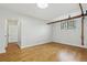 Spacious living space featuring hardwood floors, an arched doorway, a window, and exposed piping at 3132 E 17Th Ave # B, Denver, CO 80206