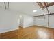 Spacious living space featuring hardwood floors, arched doorways, a window, and exposed piping at 3132 E 17Th Ave # B, Denver, CO 80206