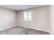 Bedroom with neutral paint, gray carpet, and large window providing lots of natural light at 280 Birch St, Bennett, CO 80102