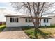 Exterior view of home with concrete driveway, trimmed lawn, and tidy siding at 280 Birch St, Bennett, CO 80102
