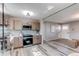 Open kitchen featuring stainless appliances, wood cabinets, modern lighting, and open floor plan at 280 Birch St, Bennett, CO 80102