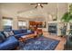Spacious living area with blue sofa, wood accents, and fireplace leading to kitchen and dining area at 6699 S Robb St, Littleton, CO 80127