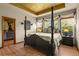 Primary bedroom showcasing wood floors, four poster bed, tray ceiling, and walk-in closet at 6699 S Robb St, Littleton, CO 80127