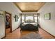 Stately primary bedroom with tray ceiling, four poster bed, wood floors and walk-in closet at 6699 S Robb St, Littleton, CO 80127