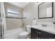 Bathroom featuring tile shower and a dark wood vanity for storage and a dark framed mirror at 10429 Quivas St, Northglenn, CO 80234