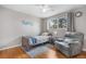 Bedroom featuring hardwood floors, a large window, and a cozy chair with soft neutral colors at 10429 Quivas St, Northglenn, CO 80234