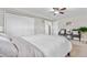Sunlit bedroom featuring neutral walls, two closets, carpet, and comfortable seating by a large window at 10429 Quivas St, Northglenn, CO 80234