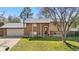 Charming brick home with a well-manicured lawn, attached garage, and inviting front entrance at 10429 Quivas St, Northglenn, CO 80234