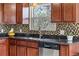 Close-up of the kitchen sink and stainless steel dishwasher with view of the backyard at 10429 Quivas St, Northglenn, CO 80234