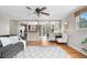 Living room with hardwood floors, neutral paint, ceiling fan, and natural light and views into kitchen and dining room at 10429 Quivas St, Northglenn, CO 80234