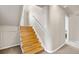 A wooden staircase with a white handrail provides access to the upper level, complemented by neutral walls and carpeted landing at 10429 Quivas St, Northglenn, CO 80234