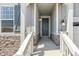Covered front entry with stone accents and white railings welcomes visitors to the home at 1871 Water Birch Way, Castle Rock, CO 80108