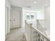 Bright hallway with gray carpet and white trim, leading to an open, sunlit area and featuring a white staircase railing at 1871 Water Birch Way, Castle Rock, CO 80108