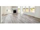 Bright living room with a fireplace, hardwood floors, and large windows allowing natural light at 1871 Water Birch Way, Castle Rock, CO 80108