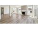 Open-concept living area with hardwood floors, a fireplace, and large windows for natural light at 1871 Water Birch Way, Castle Rock, CO 80108
