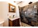 Bathroom featuring custom slate shower, granite vanity, and stone pebble floor at 2710 Rustlers Canyon Loop, Elizabeth, CO 80107