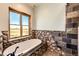 Relaxing bathroom showcasing a large soaking tub, river rock accents, and a large window with stunning views at 2710 Rustlers Canyon Loop, Elizabeth, CO 80107