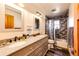 Bathroom with double vanity, granite countertops, stylish mirror, and a tiled shower at 2710 Rustlers Canyon Loop, Elizabeth, CO 80107