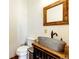 Unique bathroom featuring a rustic metal sink, toilet, and vanity at 2710 Rustlers Canyon Loop, Elizabeth, CO 80107