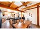 Spacious dining area flows into kitchen and living space, featuring wood beams and hardwood floors at 2710 Rustlers Canyon Loop, Elizabeth, CO 80107