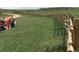 Picturesque green land with a tractor and charming split rail fence that enhances the rural aesthetic at 2710 Rustlers Canyon Loop, Elizabeth, CO 80107