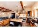 Bright open kitchen with an island, stainless steel appliances, stone accents, and an open dining area at 2710 Rustlers Canyon Loop, Elizabeth, CO 80107