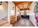 Open-concept living space with hardwood floors, exposed beams, and a stone fireplace at 2710 Rustlers Canyon Loop, Elizabeth, CO 80107