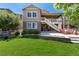 Manicured backyard with grass and a stone wall with chairs and stairs to hot tub at 16549 Prospect Ln, Broomfield, CO 80023
