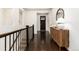 Elegant hallway featuring dark wood floors, staircase, and a decorative cabinet with a lamp at 16549 Prospect Ln, Broomfield, CO 80023
