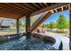 Backyard hot tub and patio with wooden cover, stone pillars, and a view at 16549 Prospect Ln, Broomfield, CO 80023