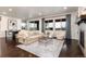 Bright living room with a comfortable sofa, matching chairs, a fireplace, and views of the outdoors at 16549 Prospect Ln, Broomfield, CO 80023