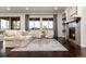 Bright living room with a comfortable sofa, matching chairs, a fireplace, and large windows that bring the outside in at 16549 Prospect Ln, Broomfield, CO 80023