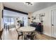 Open dining area with round table, modern lighting, and views into the living room at 12131 Melody Dr # 201, Denver, CO 80234