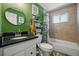Stylish bathroom with green walls, marble vanity, and shower-tub combo at 1270 S Lowell Blvd, Denver, CO 80219
